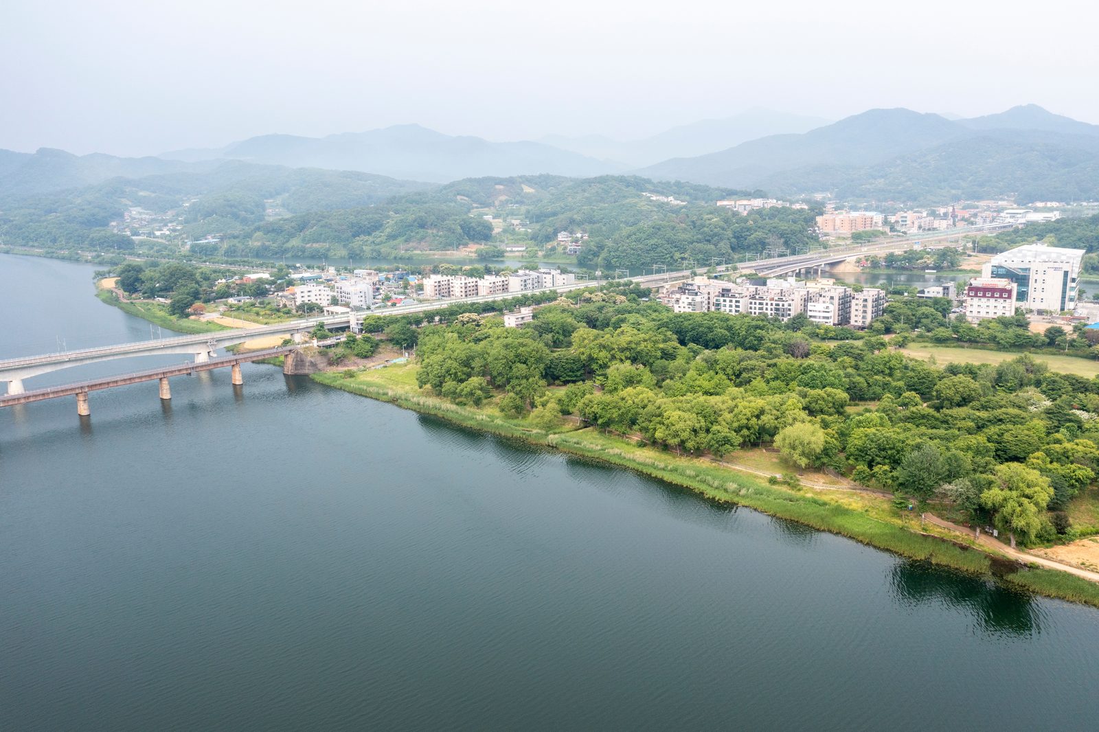 하늘에서 본 양수리로, 북한강을 가로지르는 철교와 강변 마을이 보입니다.